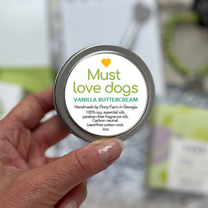 MUST LOVE DOGS CANDLE - 100% soy. Non-toxic. Carbon-neutral. Lead-free cotton wick. Made with essential oils and paraben-free fragrance oils for a vanilla buttercream scent. Hand-poured into a travel tin with lid. Handmade by Finny Farm in Georgia.