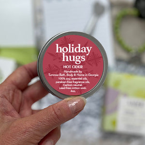 HOT CIDER SOY CANDLE - The warm scent of oak barrel apple cider combined with mulled spices of clove, cinnamon, hints of orange and vanilla. 100% soy candle. Handmade by Turnrow Bath, Body &amp; Home in Georgia. Comes in travel size tin with lid. 4 oz. Aprox. 15-20 hr burn time. Women-owned small business.