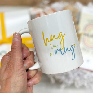 Hug in a Mug - A sweet mug to fill their cup with their favorite huggy beverage. Created by the Hug Box. Ceramic. 11oz. Dishwasher and microwave safe.