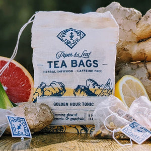 GOLDEN HOUR TONIC TEA - Caffeine-free artisan tea made of all-natural ingredients. Bursts of spicy ginger, smooth turmeric, sweet pineapple and grapefruit. Handcrafted by Piper and Leaf in Alabama. 9 silky pyramid sachets ready to brew.